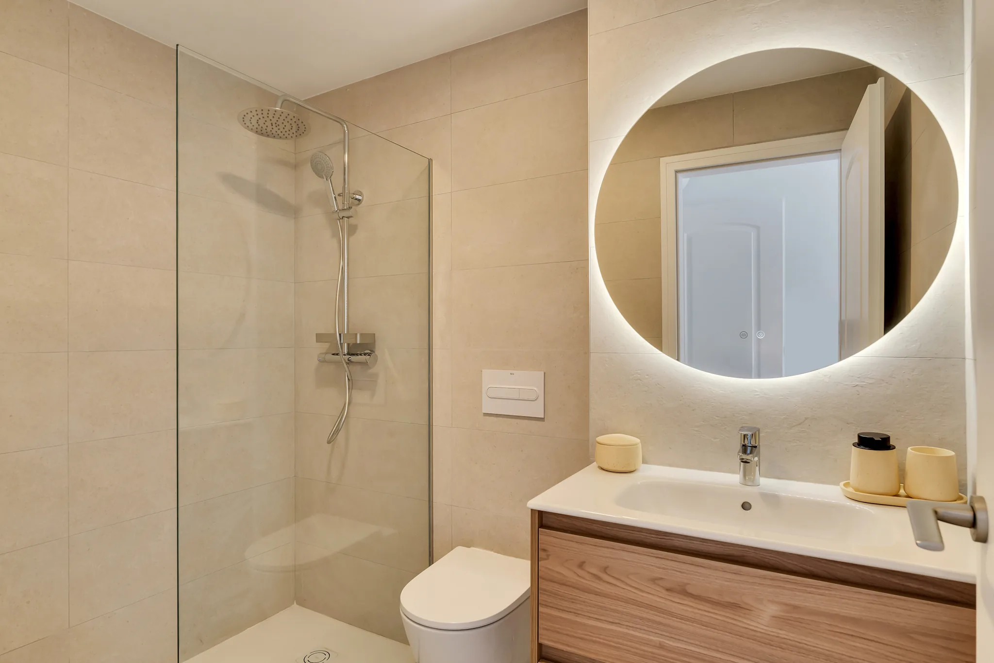 La Brisa bathroom — backlit mirror and warm wood vanity
